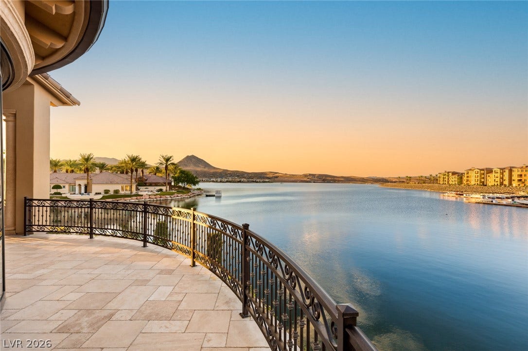 7 Lido Nord, Henderson, NV 89011 A spacious stone balcony overlooks expansive water vistas and distant mountain peaks under a twilight sky.