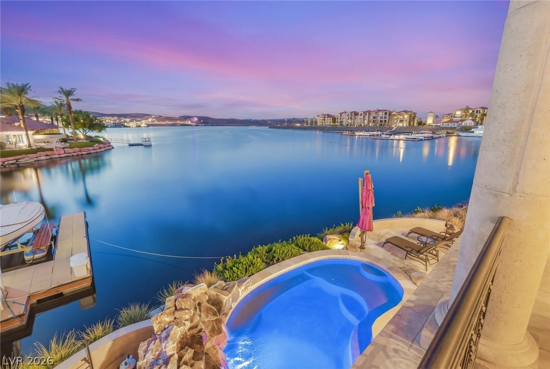 7 Lido Nord, Henderson, NV 89011 An inviting stone-bordered spa overlooks tranquil waters, showcasing sweeping lakeside panoramas.