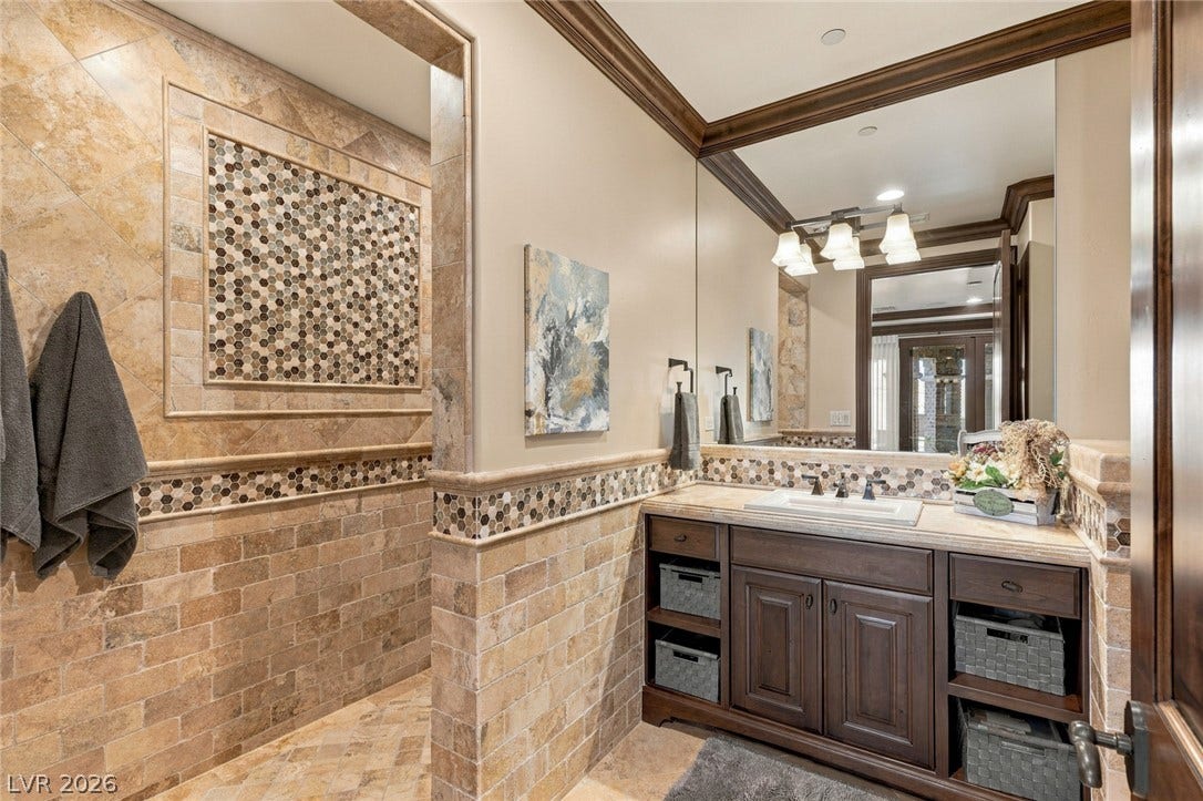 7 Lido Nord, Henderson, NV 89011 Rich travertine tilework and warm wood trim define this elegantly crafted bathroom space.