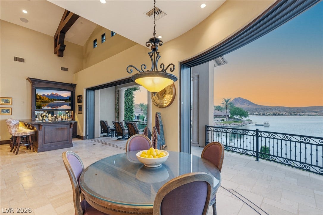 7 Lido Nord, Henderson, NV 89011 Retractable glass doors frame a picturesque lakeside view from the tiled dining area.