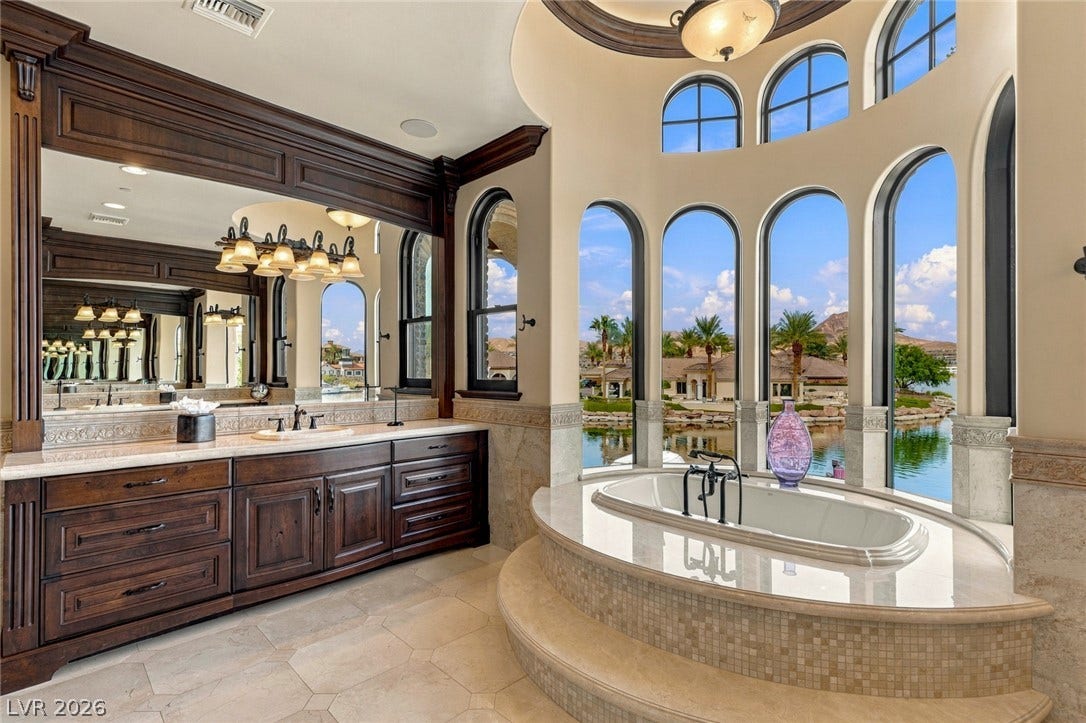 7 Lido Nord, Henderson, NV 89011 Arched windows frame tranquil water views from a elevated soaking tub alcove.