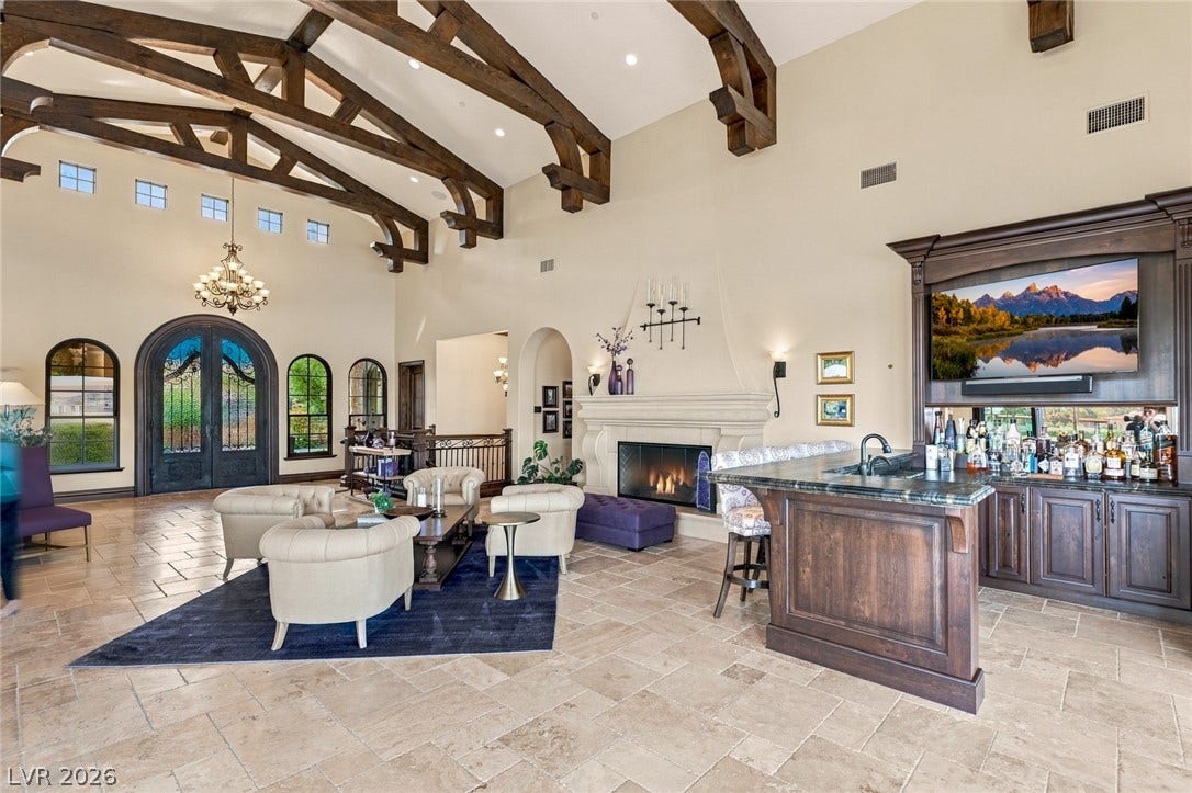 7 Lido Nord, Henderson, NV 89011 Massive exposed trusses span soaring ceilings above a custom wet bar and stone fireplace.