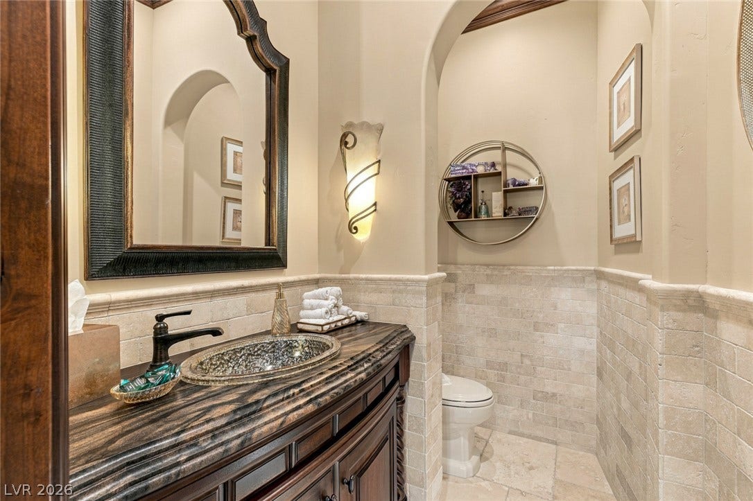 7 Lido Nord, Henderson, NV 89011 Elegant stone counters and wainscoting define this classical powder room.