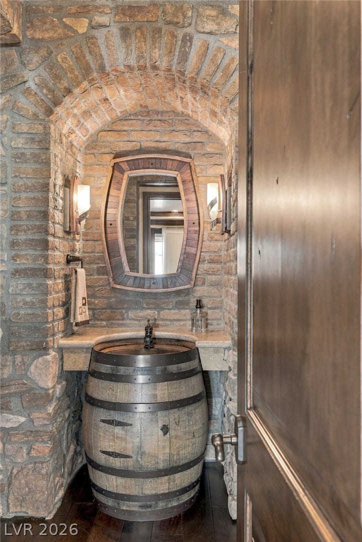 7 Lido Nord, Henderson, NV 89011 Exposed stone walls and a unique barrel vanity define this rustic powder room entryway.