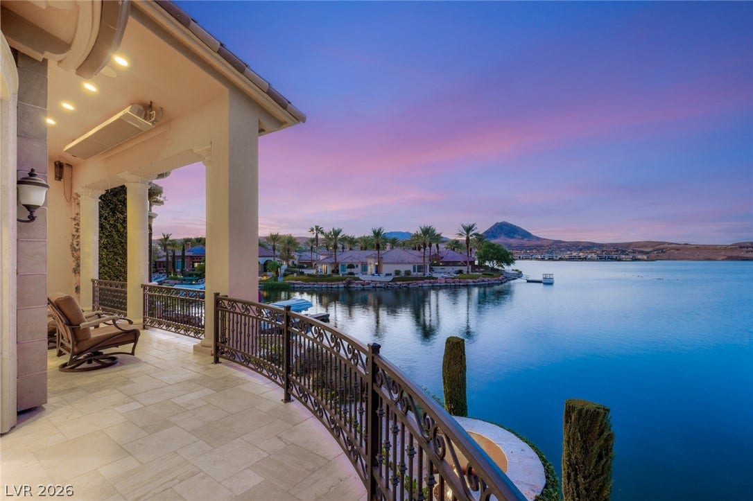 7 Lido Nord, Henderson, NV 89011 Sweeping water views stretch past the stone-paved veranda under a colorful evening sky.