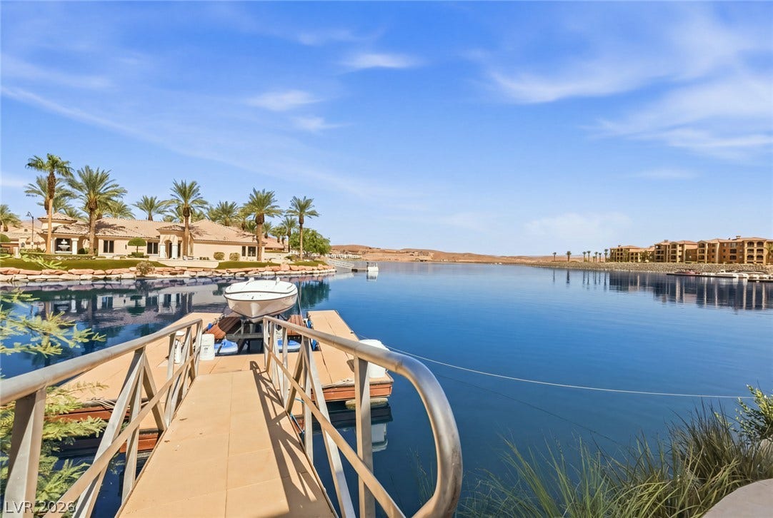 7 Lido Nord, Henderson, NV 89011 A private boat dock extends into calm blue waters under a clear sky.