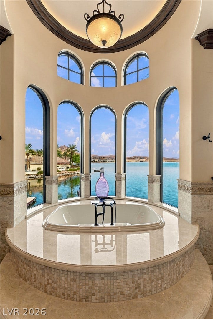 7 Lido Nord, Henderson, NV 89011 Dramatic arched windows encircle a sunken soaking tub overlooking calm, blue waterfront views.