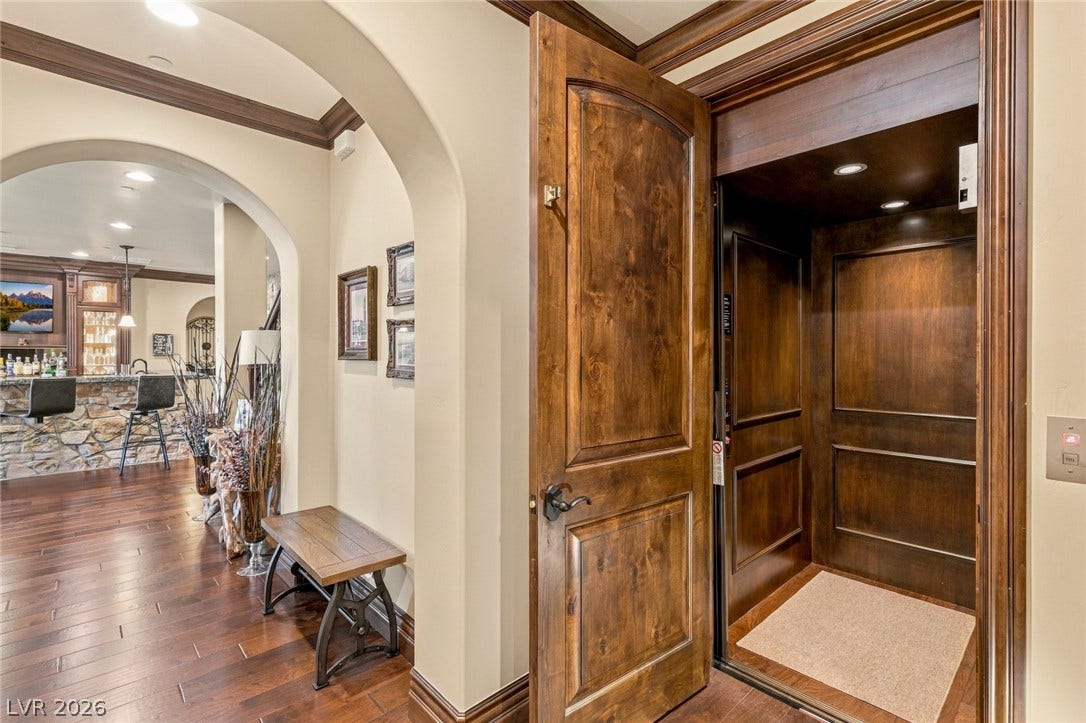 7 Lido Nord, Henderson, NV 89011 Rich wood trim and arched transitions guide the eye toward a private residential elevator.