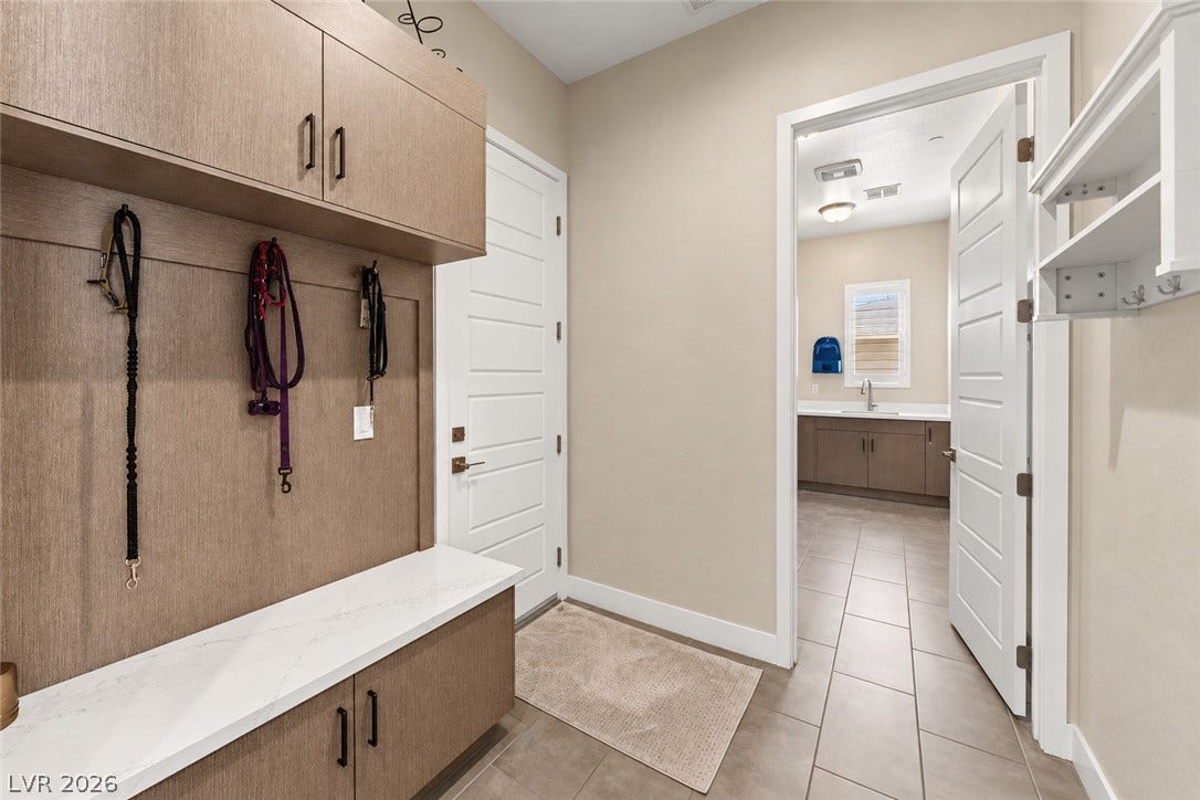 5475 Grambley Street, Las Vegas, NV 89149 A functional mudroom entry includes custom built-in cabinetry and stone-look tile flooring leading to the laundry.