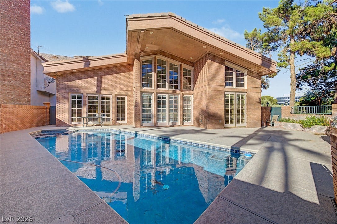 1105 Broadmoor Avenue, Las Vegas, NV 89109 An inviting backyard pool mirrors the striking geometric brick architecture and expansive windows.