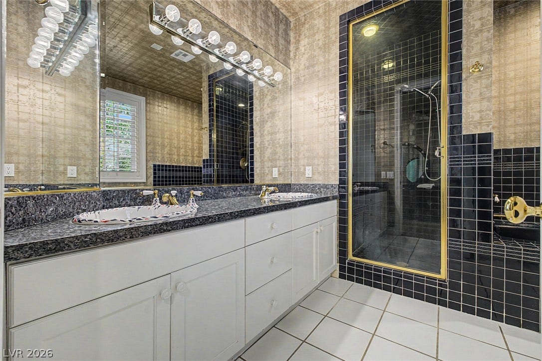 1105 Broadmoor Avenue, Las Vegas, NV 89109 A spacious double vanity and a glass-enclosed shower highlight this classic tile-floored bathroom.