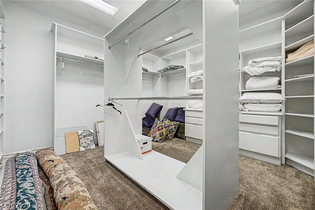 1105 Broadmoor Avenue, Las Vegas, NV 89109 A spacious custom walk-in closet boasts extensive built-in shelving, hanging rods, and carpeting.