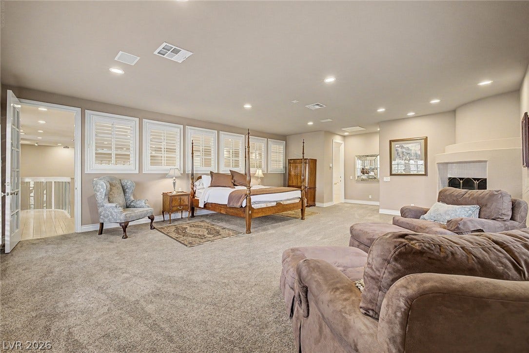 1105 Broadmoor Avenue, Las Vegas, NV 89109 A spacious bedroom features plush carpeting, a corner fireplace, and plantation shutters.