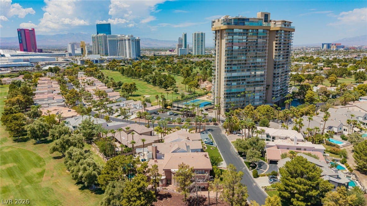 1105 Broadmoor Avenue, Las Vegas, NV 89109 Towering high-rises overlook lush golf course fairways under clear desert skies.
