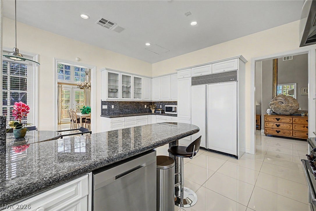 1105 Broadmoor Avenue, Las Vegas, NV 89109 Gleaming stone countertops and matching tiled floors anchor this bright, open kitchen space.