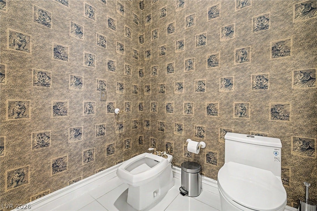 1105 Broadmoor Avenue, Las Vegas, NV 89109 An elegant powder room showcases patterned walls and classic white fixtures.
