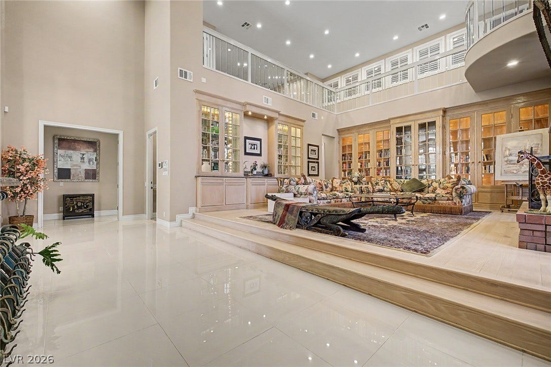 1105 Broadmoor Avenue, Las Vegas, NV 89109 Soaring ceilings and polished tile floors frame this grand sunken living room with built-in bookcases.