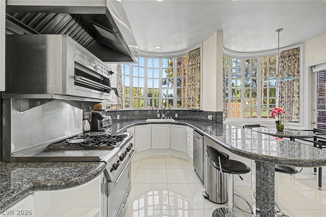 1105 Broadmoor Avenue, Las Vegas, NV 89109 Gleaming stone countertops and matching curved bay windows frame this modern culinary space.