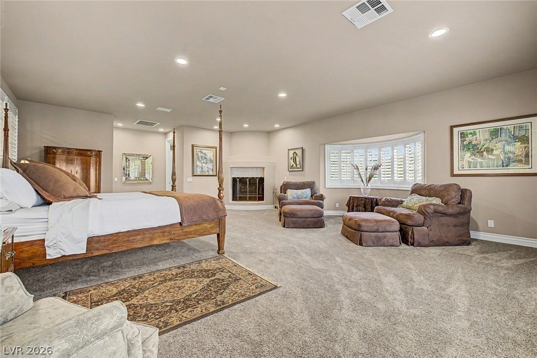 1105 Broadmoor Avenue, Las Vegas, NV 89109 A spacious bedroom features plush carpet, recessed lighting, a fireplace, and a large bay window.