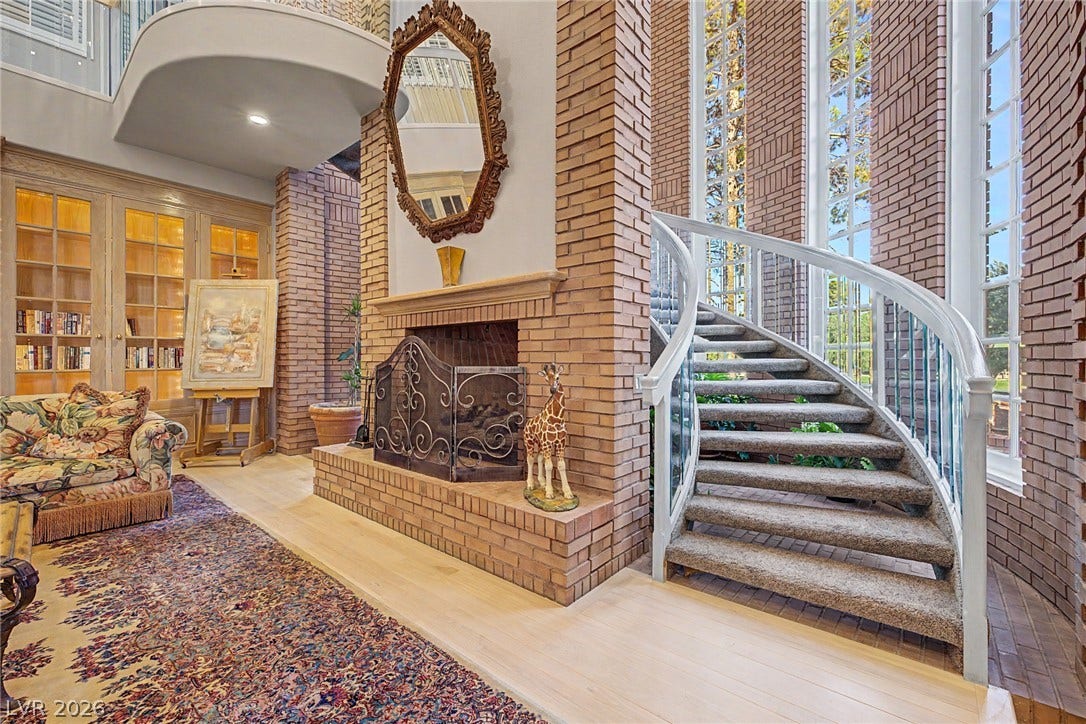 1105 Broadmoor Avenue, Las Vegas, NV 89109 Towering brick accents and a winding staircase frame this double-height living space.