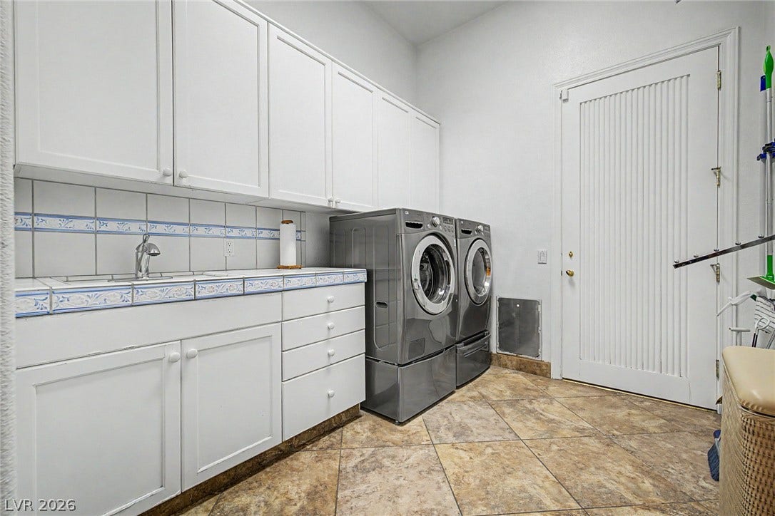 1105 Broadmoor Avenue, Las Vegas, NV 89109 Ample white cabinetry and tiled countertops provide abundant storage and workspace in this functional laundry room.