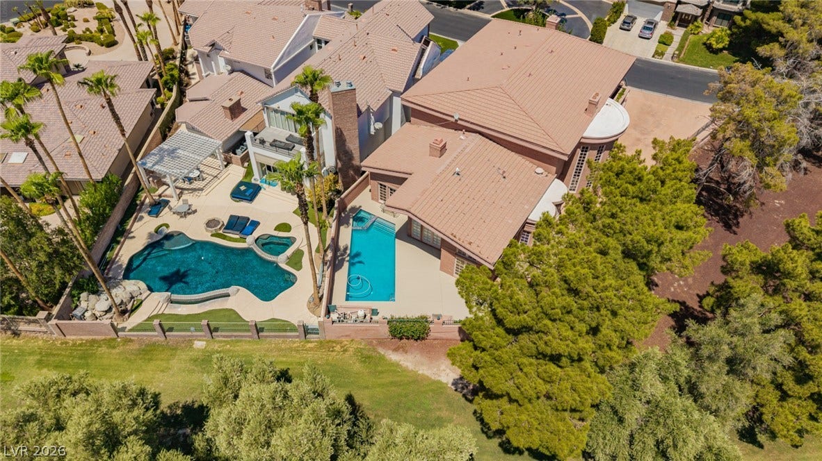 1105 Broadmoor Avenue, Las Vegas, NV 89109 An aerial perspective captures the backyard swimming pool alongside the tiled rooflines of the residence.