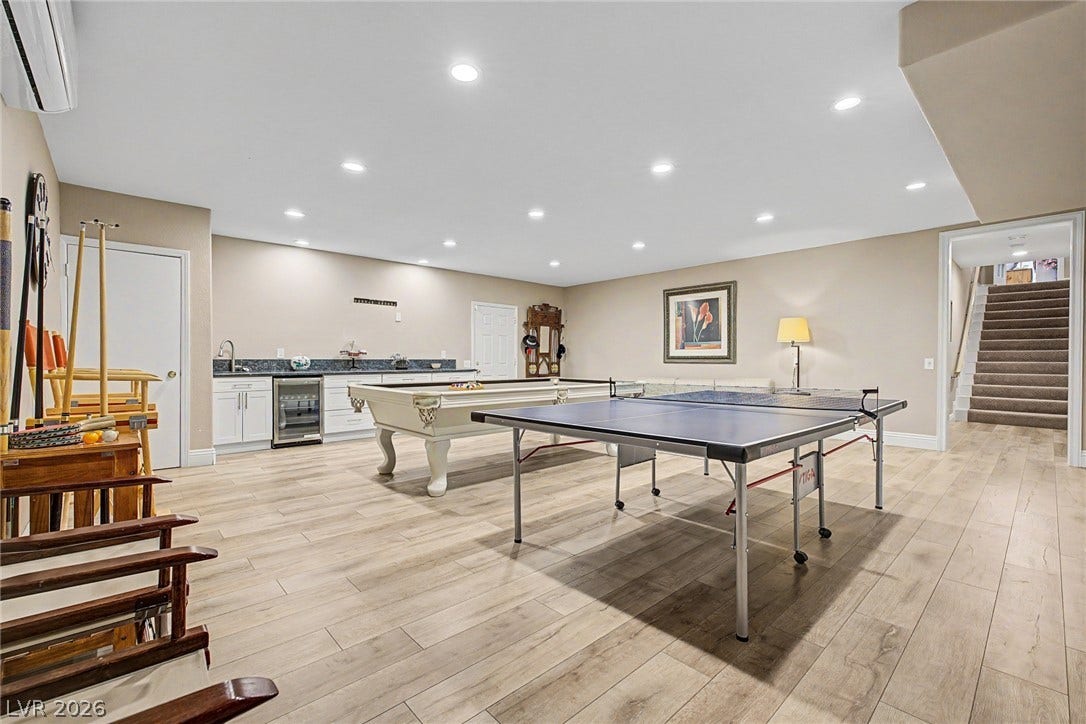 1105 Broadmoor Avenue, Las Vegas, NV 89109 Recessed lighting illuminates this versatile recreation space featuring wood-look floors and a wet bar.