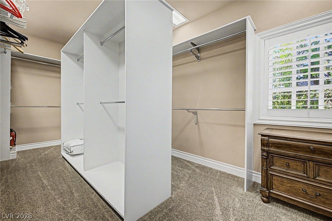 1105 Broadmoor Avenue, Las Vegas, NV 89109 A spacious custom walk-in closet boasts generous built-in shelving, plush carpeting, and natural light.