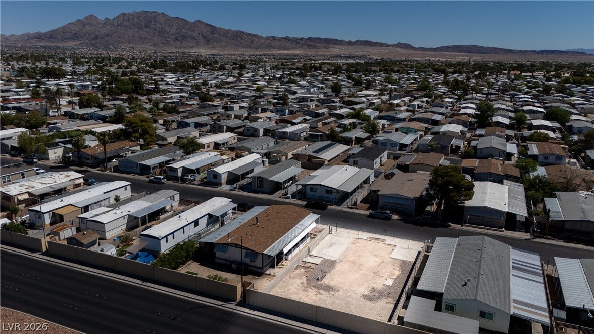 3499 Allegheny Drive, Las Vegas, NV 89122 An aerial perspective showcases a suburban residential neighborhood backdropped by majestic mountain ranges.