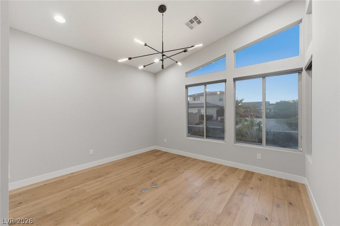 8380 Mojave Creek Court, Las Vegas, NV 89113 High ceilings and modern wood floors anchor this versatile room illuminated by geometric windows.