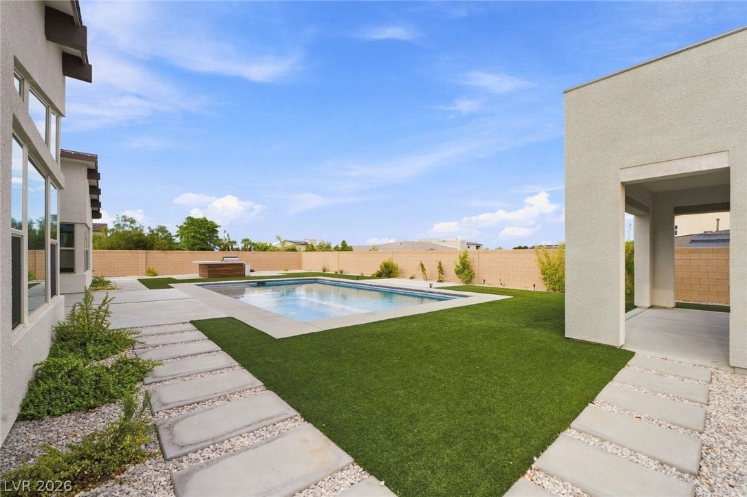 8380 Mojave Creek Court, Las Vegas, NV 89113 A sparkling swimming pool anchors this modern backyard surrounded by manicured pathways.