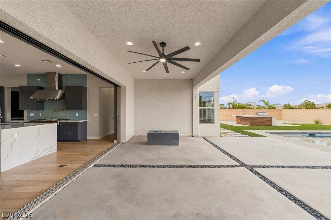 8380 Mojave Creek Court, Las Vegas, NV 89113 Pocket sliding doors seamlessly connect the indoor living spaces to the covered concrete patio.