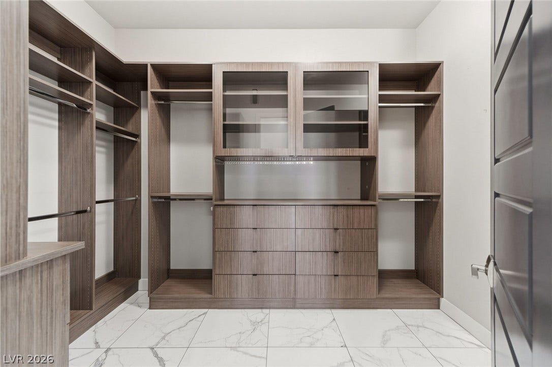 8380 Mojave Creek Court, Las Vegas, NV 89113 Custom cabinetry and polished stone tile floors define this functional walk-in closet space.