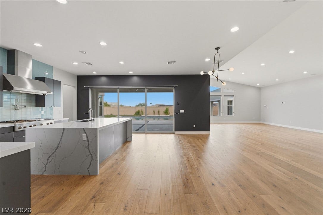 8380 Mojave Creek Court, Las Vegas, NV 89113 Gleaming hardwood floors and a modern waterfall island anchor this expansive open-concept living space.