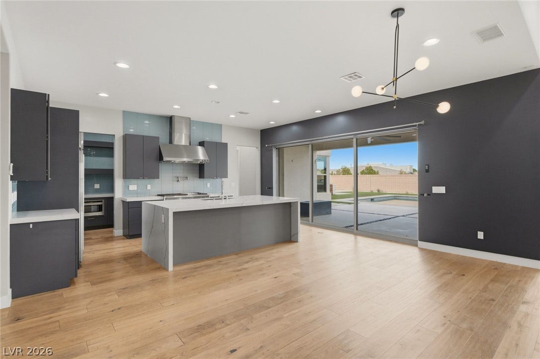 8380 Mojave Creek Court, Las Vegas, NV 89113 Sliding glass doors connect the open-concept living area and modern kitchen to the backyard.