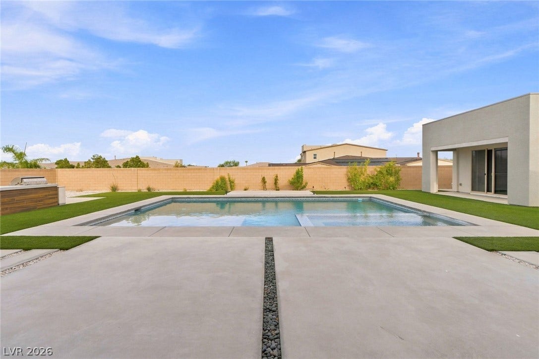 8380 Mojave Creek Court, Las Vegas, NV 89113 An inviting backyard oasis centers around a sparkling swimming pool framed by clean concrete decking.