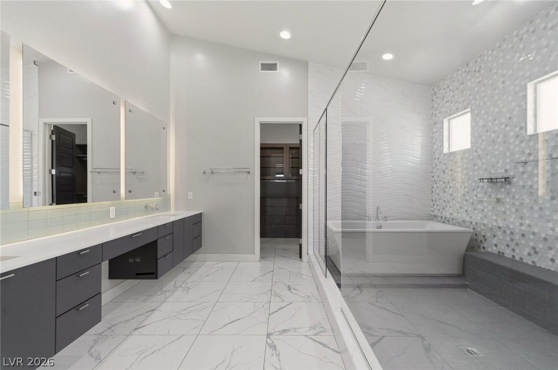 8380 Mojave Creek Court, Las Vegas, NV 89113 Gleaming marble-patterned tile floors and a glass-enclosed wet room anchor this modern bath retreat.