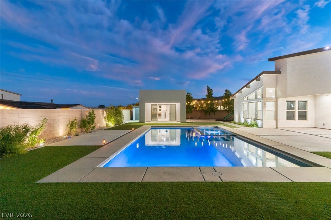 8380 Mojave Creek Court, Las Vegas, NV 89113 A sparkling geometric pool anchors this modern backyard surrounded by concrete decking and lush turf.