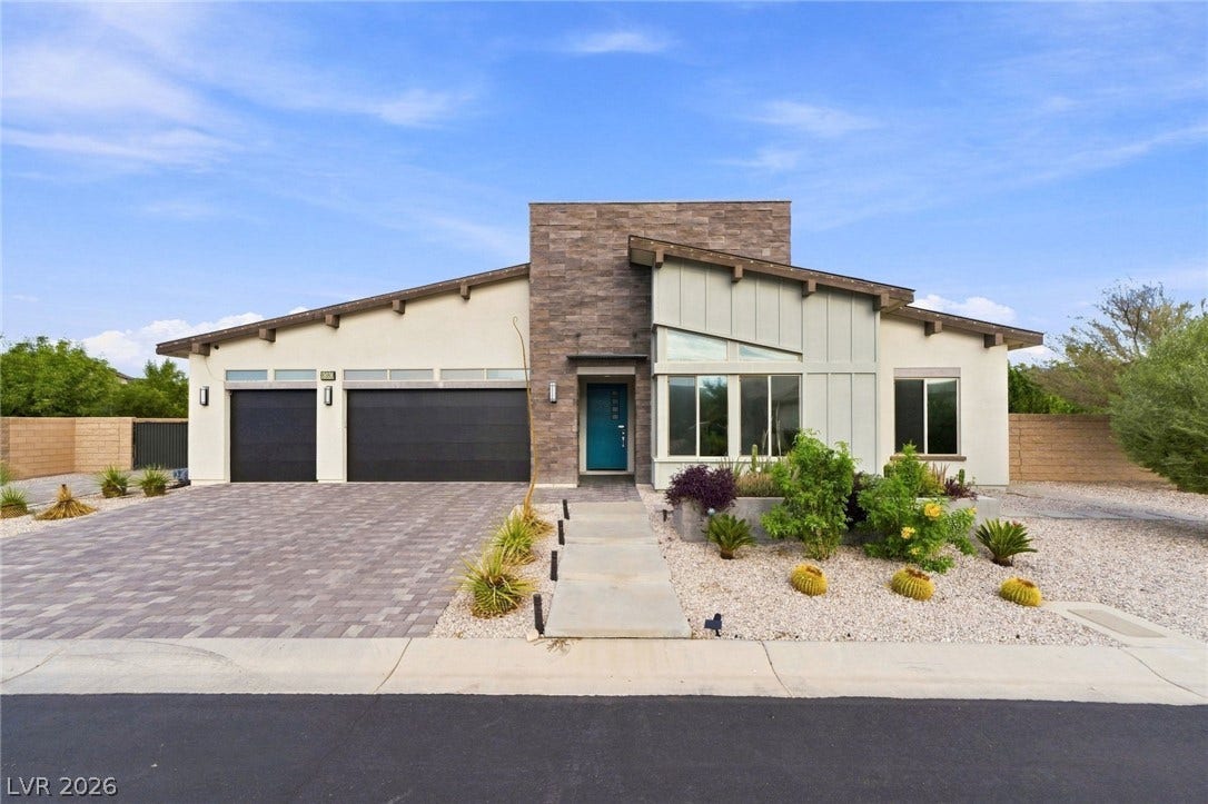 8380 Mojave Creek Court, Las Vegas, NV 89113 Modern architectural lines define this single-story home featuring stone accents and desert landscaping.