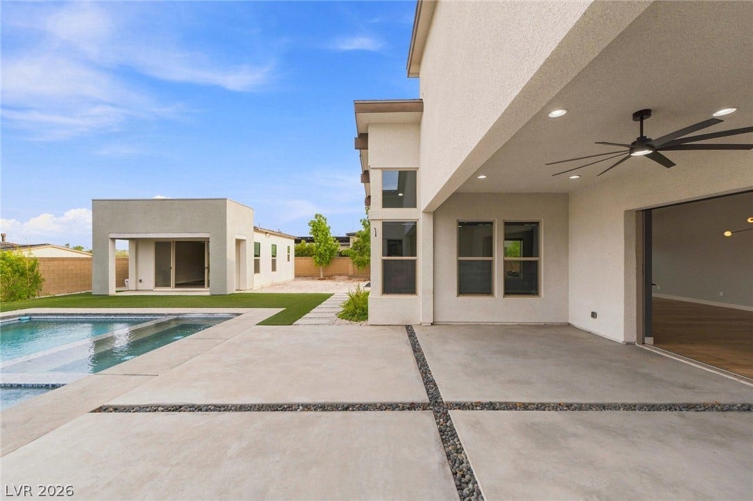 8380 Mojave Creek Court, Las Vegas, NV 89113 A spacious covered patio overlooks a modern pool and detached pool house.