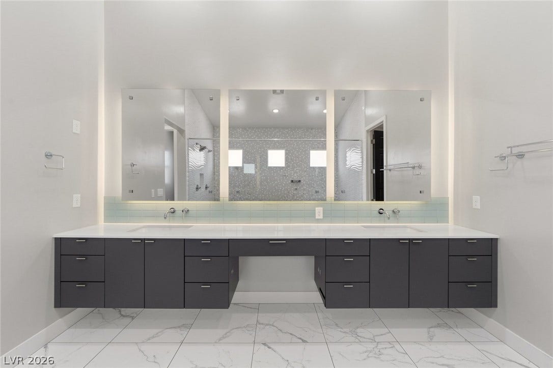 8380 Mojave Creek Court, Las Vegas, NV 89113 Polished tile flooring and an expansive floating vanity with double sinks anchor the modern bathroom.