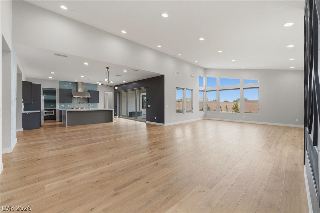 8380 Mojave Creek Court, Las Vegas, NV 89113 Warm hardwood flooring flows across this airy living space with tall windows.