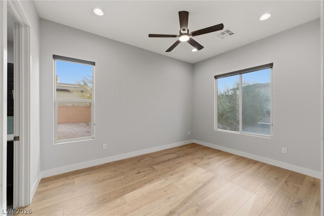 8380 Mojave Creek Court, Las Vegas, NV 89113 Recessed lighting and wide windows illuminate the clean lines of this modern bedroom.