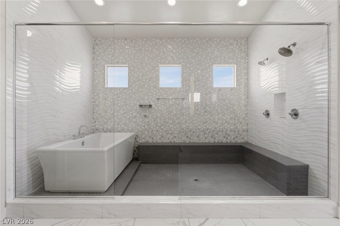 8380 Mojave Creek Court, Las Vegas, NV 89113 An expansive wet room enclosure highlights textured wall tiling and a integrated soaking tub.