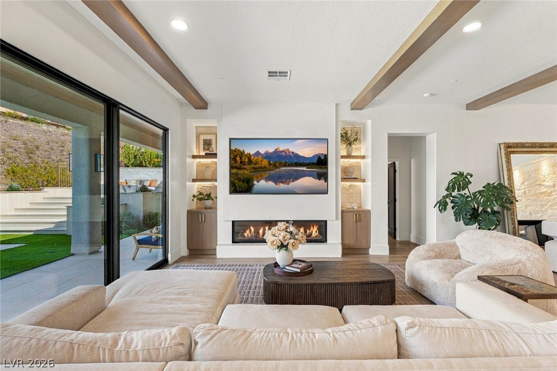 40 Stonemark Drive, Henderson, NV 89052 Beamed ceilings and a sleek linear fireplace define this modern open-concept living space.