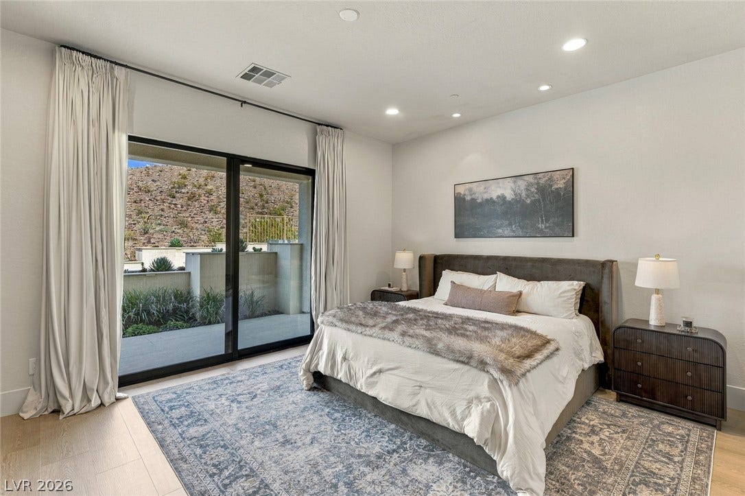 40 Stonemark Drive, Henderson, NV 89052 Glass sliding doors open from a modern bedroom to a private patio space.