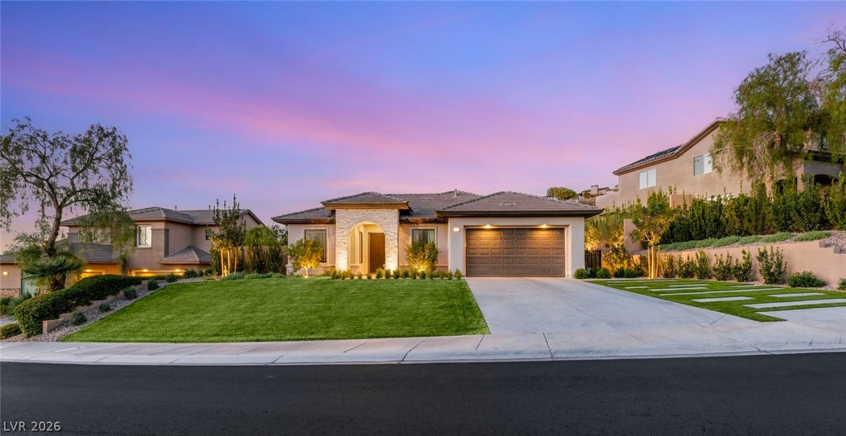 40 Stonemark Drive, Henderson, NV 89052 A stone-accented arched entryway and manicured lawn highlight this modern single-story exterior.