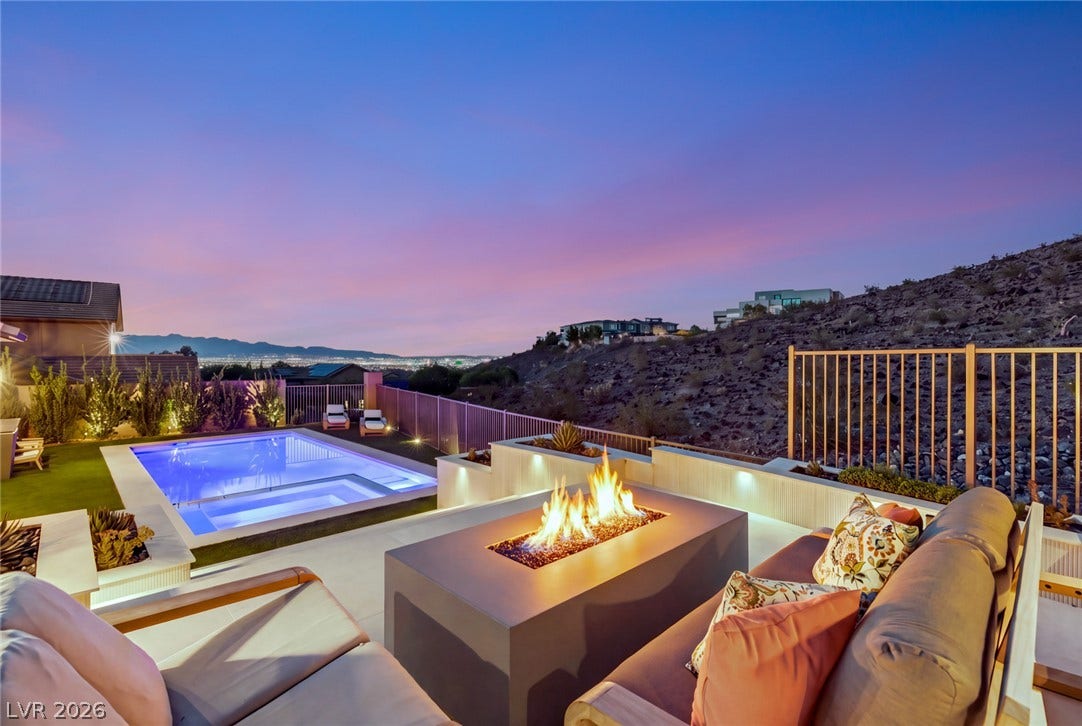 40 Stonemark Drive, Henderson, NV 89052 An inviting outdoor fireplace terrace overlooks a sparkling swimming pool and distant city lights.