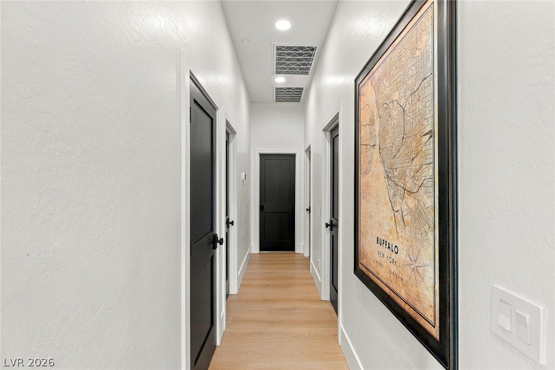 40 Stonemark Drive, Henderson, NV 89052 Smooth plaster walls and warm wood flooring define this elegant transitional hallway.