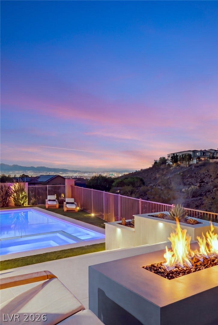 40 Stonemark Drive, Henderson, NV 89052 An inviting outdoor fire table overlooks a swimming pool against a panoramic desert valley view.
